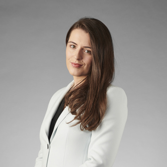 Pauline McCulloch of Burness Paull standing in a white jacket in front of a plain background.